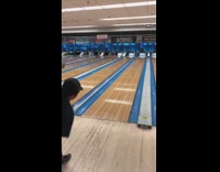 Guy gives signal to friend play bowling