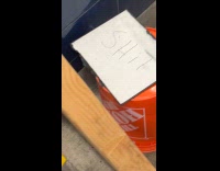 Poop inside orange bucket on subway staircase