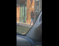 woman storefront dancing holds belt large jacket