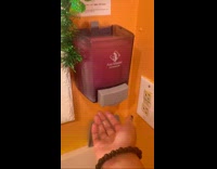 Woman dips hand on soap dispenser