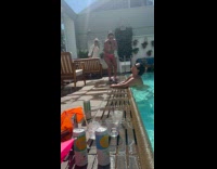 Woman in bikini poses by the poolside