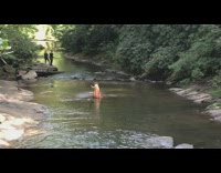 Woman striped yellow orange dress creek drone