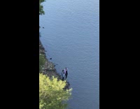 People pose and take pictures by a lake