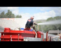 Firemen spray water to people Independence day parade