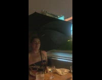 Girls hold umbrellas rain restaurant patio 