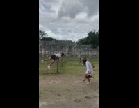Guy white shirt handstand railings rock poles