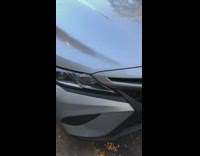 Motorcycle squished in between two cars