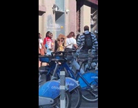 Woman walks on sidewalk with pet snake