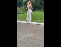 Woman in gray tube top poses in front of the house of Elvis Presley