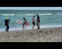 Woman hold surfboard walk at windy beach