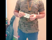 Guy pulls playing card through green shirt 