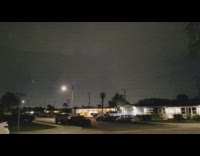 Lightning strike night sky neighborhood houses cars