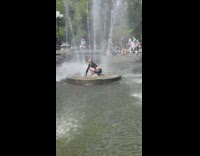 Man stretches in middle of water fountain