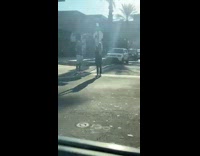 Man holds up a boom box radio at the sidewalk