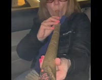 NSFW Woman smokes a giant blunt in the passenger seat of a car