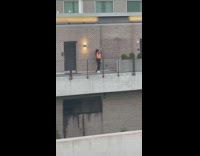 Two girls dance on building orange top