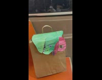 Art of a paper bag with a sea creature drawing hanging out