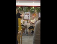 Man white shirt holds up plate for picture