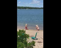 Two women bikini beach shore middle finger