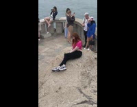 Woman pink shirt sit pose on rock