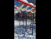 Snow arches hang on monkey bars playgound