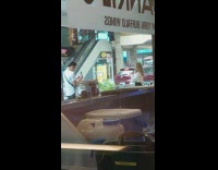 Woman in white sweater eats ice cream on the sidewalk