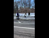 Guy walks barefoot across park asphalt ground