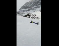 Guy on snowboard attempts backflip fail mountain