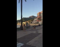 Two girls wearing dresses pose together guy