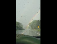 Rain droplets go up windshield car rainbow
