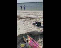 Guy stands on beach shore 