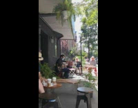 Guy sits outside coffee shop plays guitar 