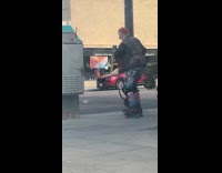 Man with skates and dog dances on sidewalk