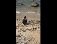 Grey shorts yellow water bottle guy beach 
