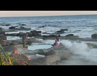Couple kiss sit rock beach smoke effect
