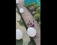 two girls dogs sit on boardwalk water