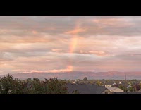 Submitter shows sunset overlooking mountains with rainbow