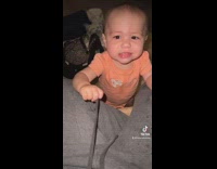 Baby in orange shirt mocks mom tired go to sleep