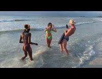 Woman green bikini reflector hit by waves