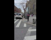 Guy wearing spiderman costume crosses the street