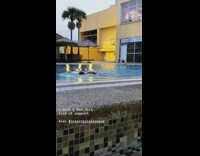 Girl records guy swimming in pool