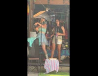 Collab IITW - Two women sings and dances on the sidewalk store