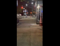 Woman with headphones strip dance at sidewalk