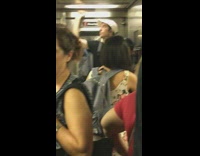 John Mulaney rides subway train white hat 