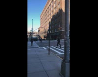 Strong winds cause pole on city sidewalk to shake back and forth
