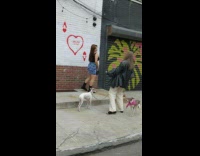 Girl takes picture in front of white wall with heart