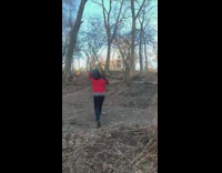 Guy carries wood on shoulder across park 