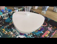 Artist showing the process of an acrylic pour for a small table top