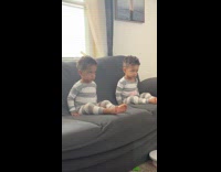 Twin boys move the same on couch TV