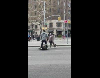 2 guys ride skateboard to carry tree 